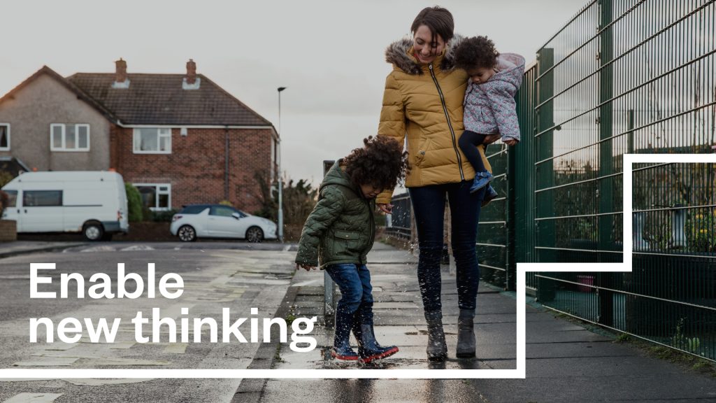 An image of a parent and two children, with the text "Enable new thinking".